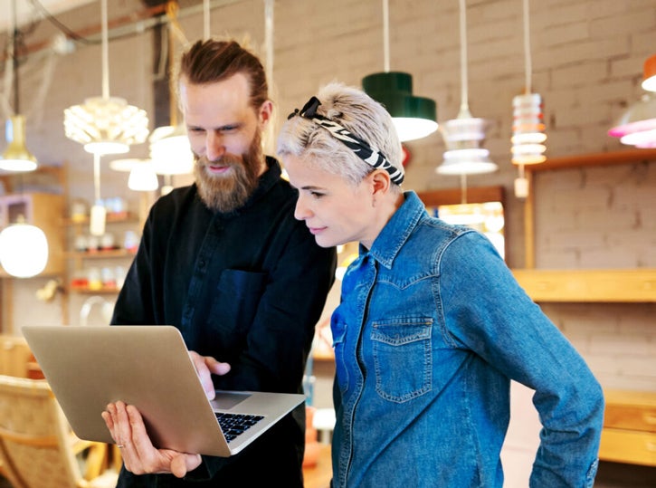 two Lumos employees looking at a laptop