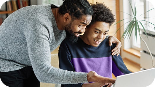 father and son looking at computer together