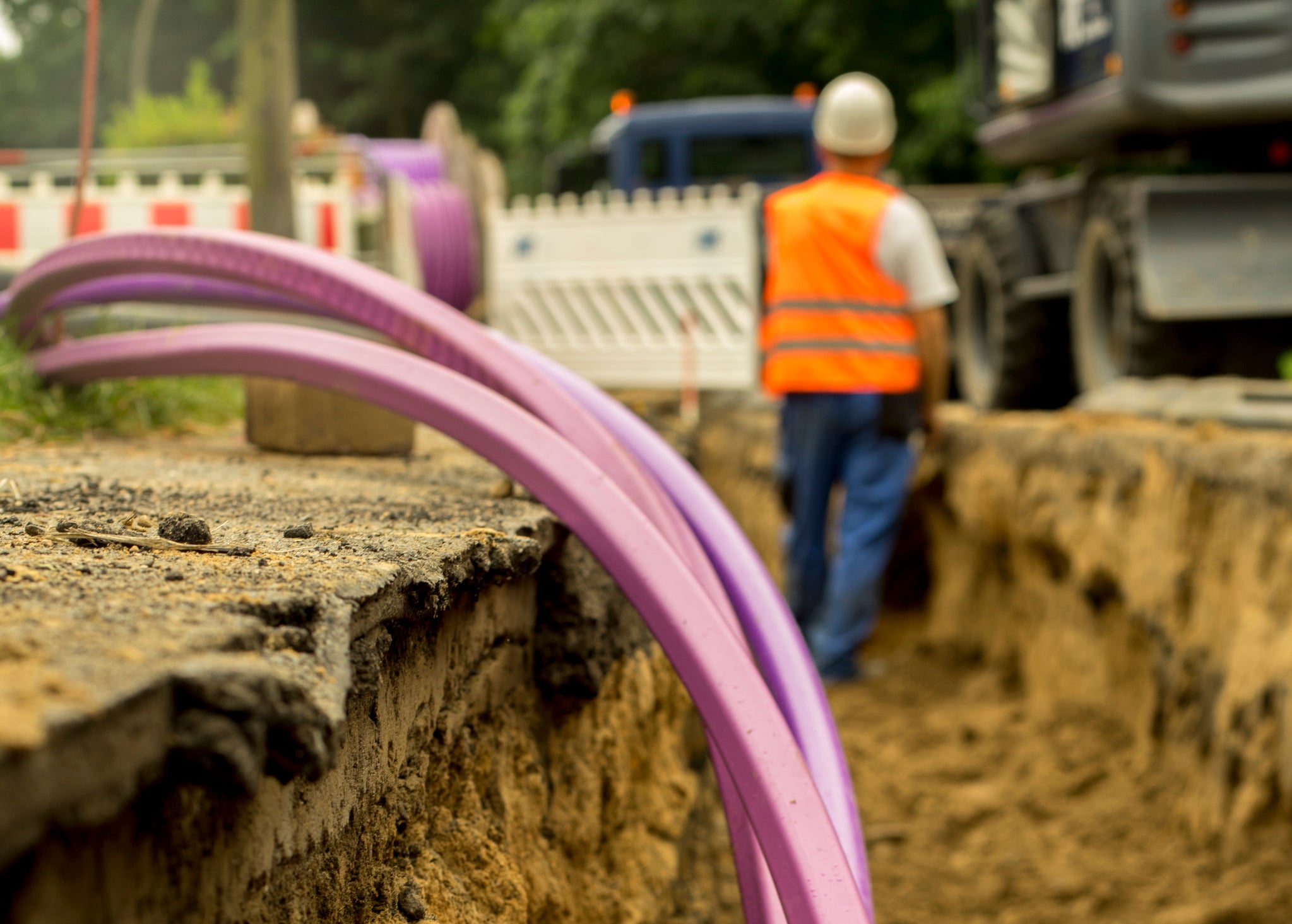 roll of fiber with man in safety vest in background