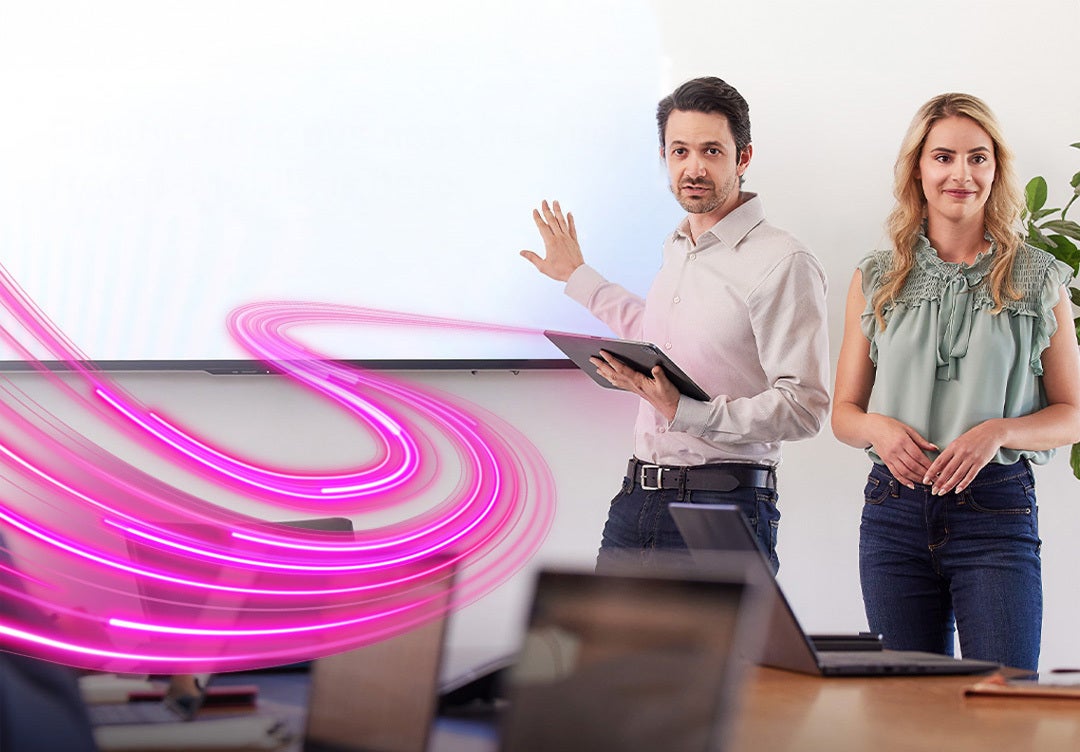 Man and woman standing in front of white board with a purple ribbon extending toward screen